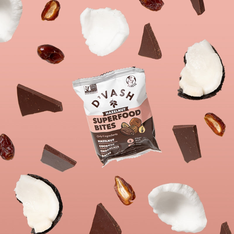 hazelnut superfood bite on pink background with coconut chocolate and dates floating