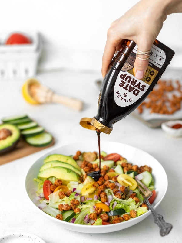 date syrup drizzled onto healthy salad